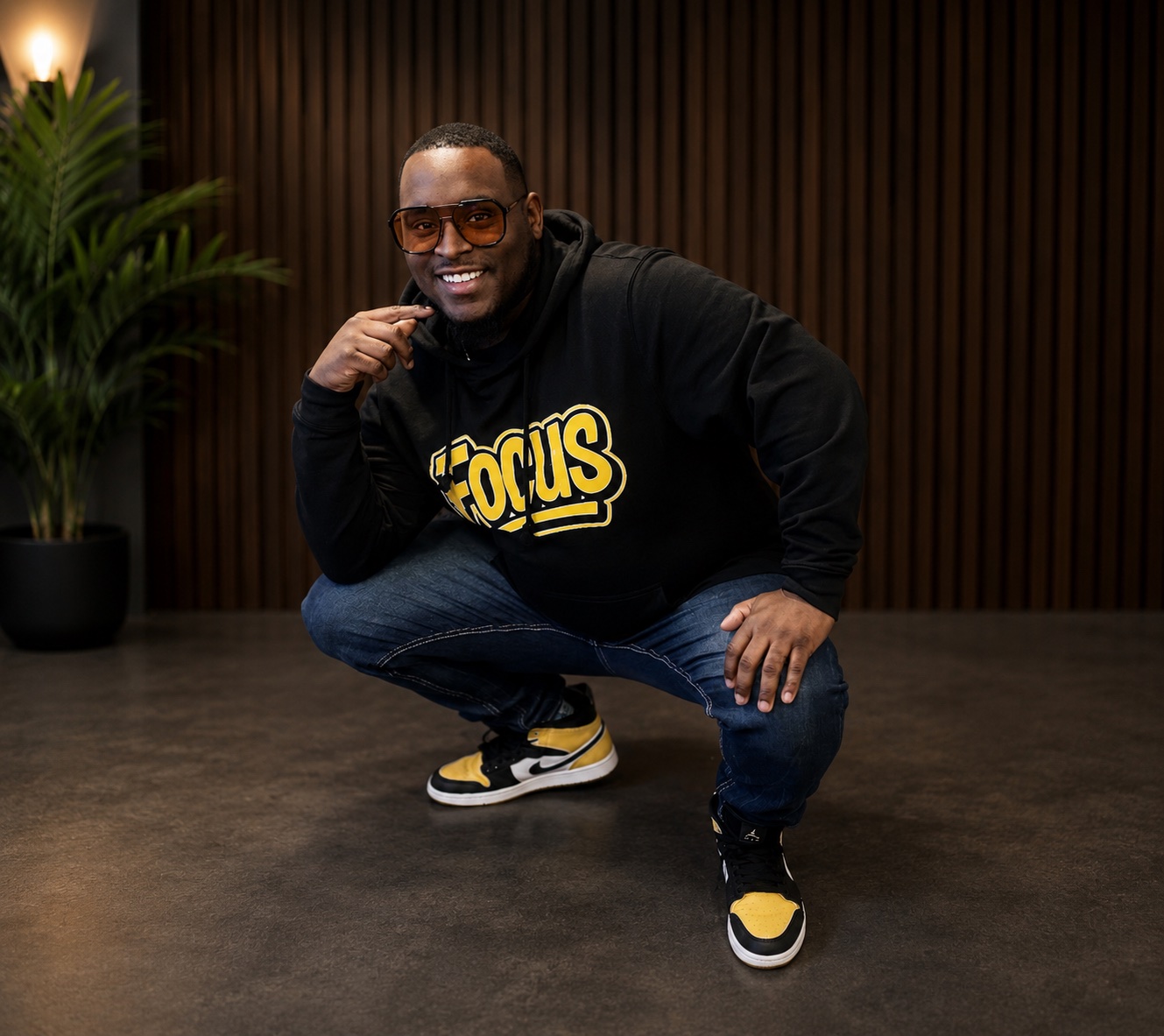 Sheldon Brown crouching in a black and gold Focus hoodie