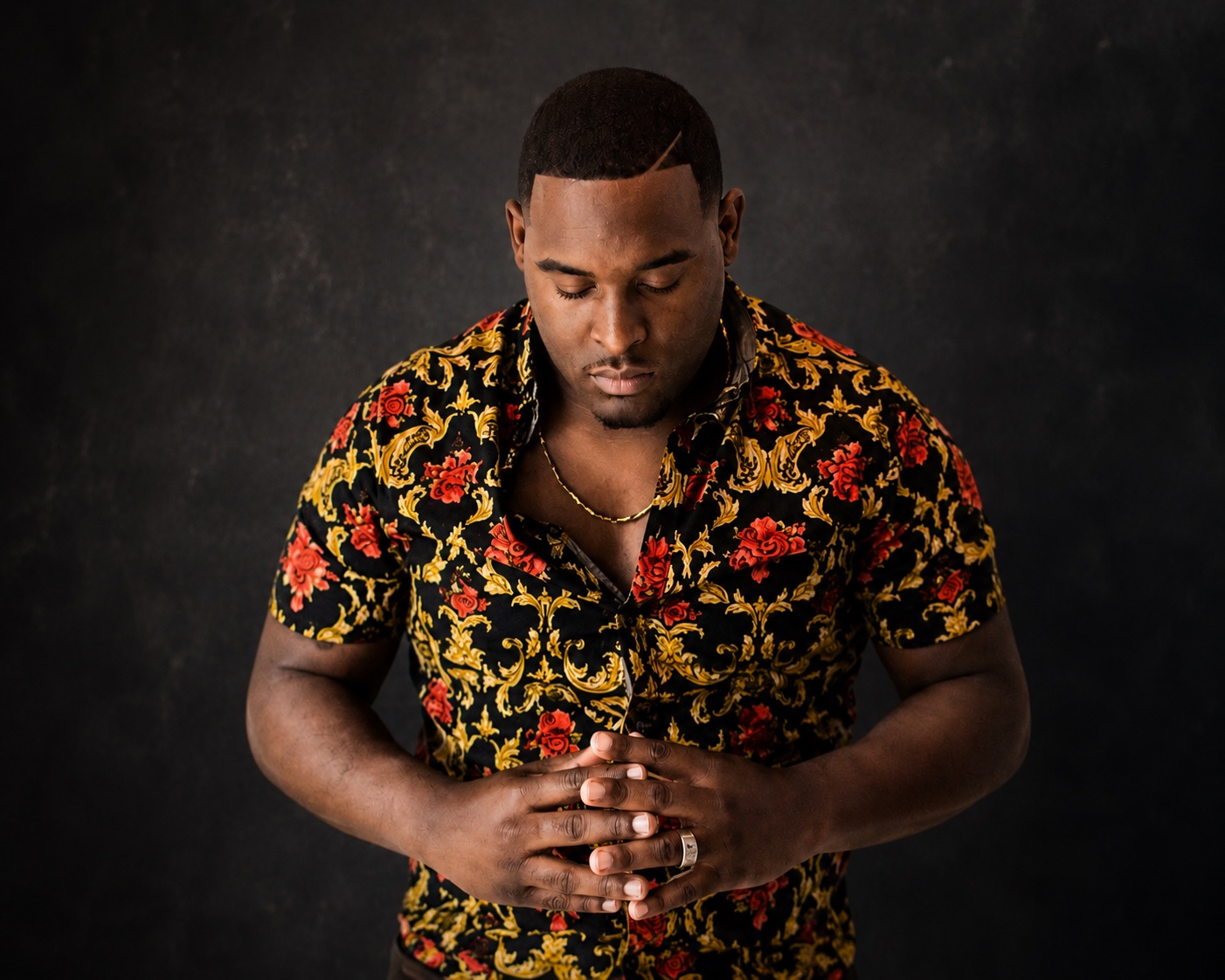 Sheldon Brown with head bowed and hands folded in prayer